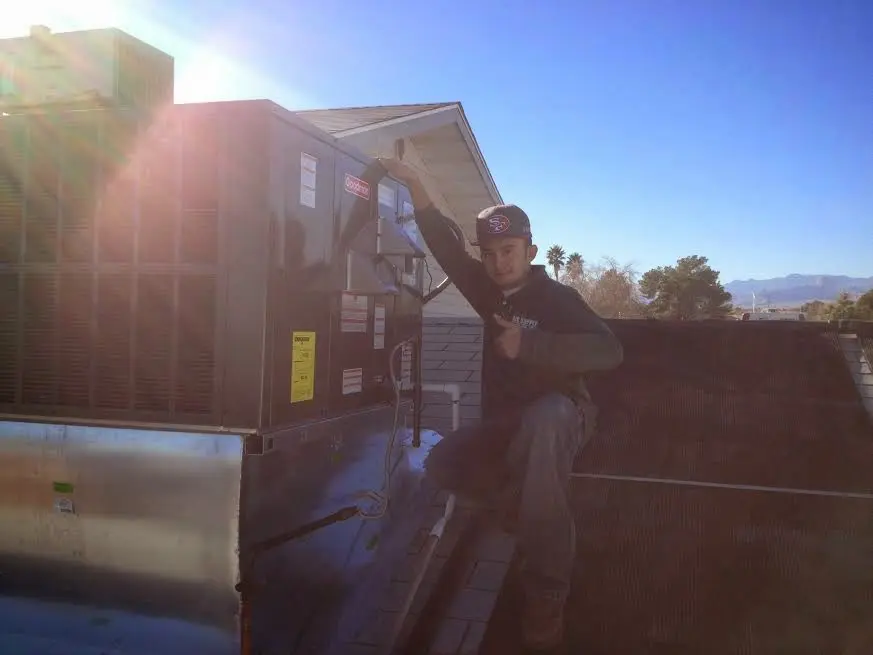 HVAC technician performing Heat Pump Repair on a rooftop unit in Pacific